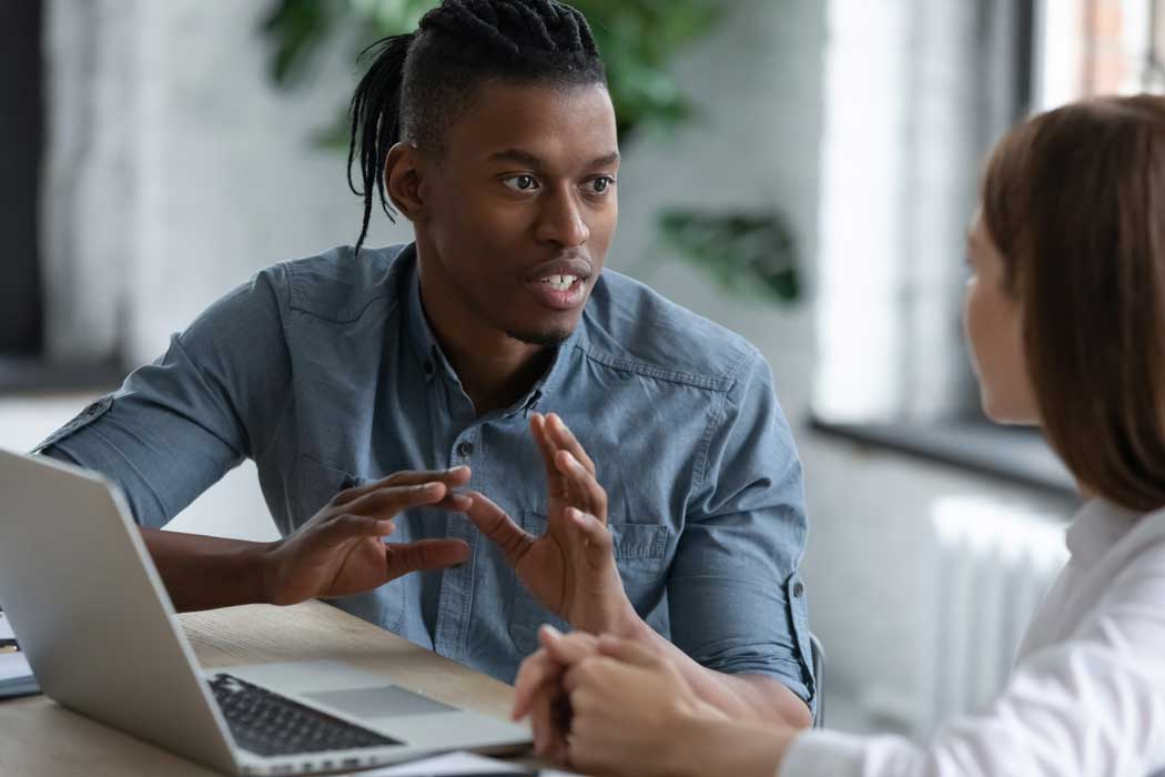 Two careers advisers sat at desk with laptop having a discussion